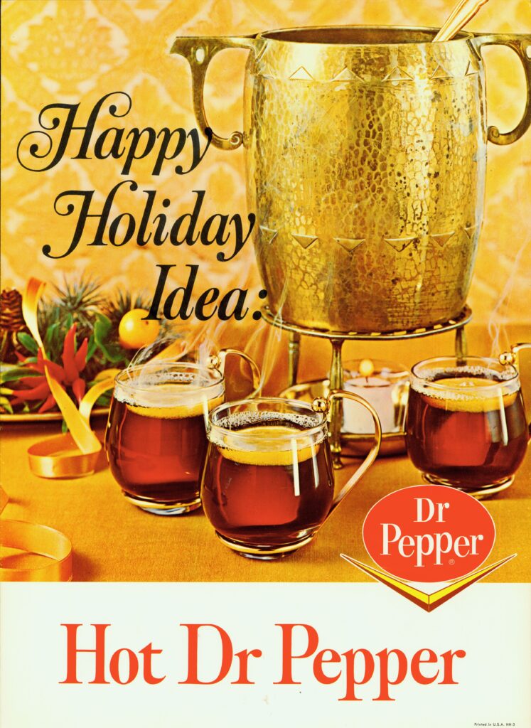 An image of a 1960s print advertisement featuring the unconventional holiday beverage, HOT Dr Pepper. There is a gold open-top kettle that is being warmed by a lit candle underneath. Clear glass mugs of HOT Dr Pepper, each with a slice of lemon on top, are in the foreground. There are holiday decorations as accents. The 1960s Dr Pepper bounced P logo with the chevron is in the bottom right corner, and Hot Dr Pepper is featured in bold red letters across the bottom.